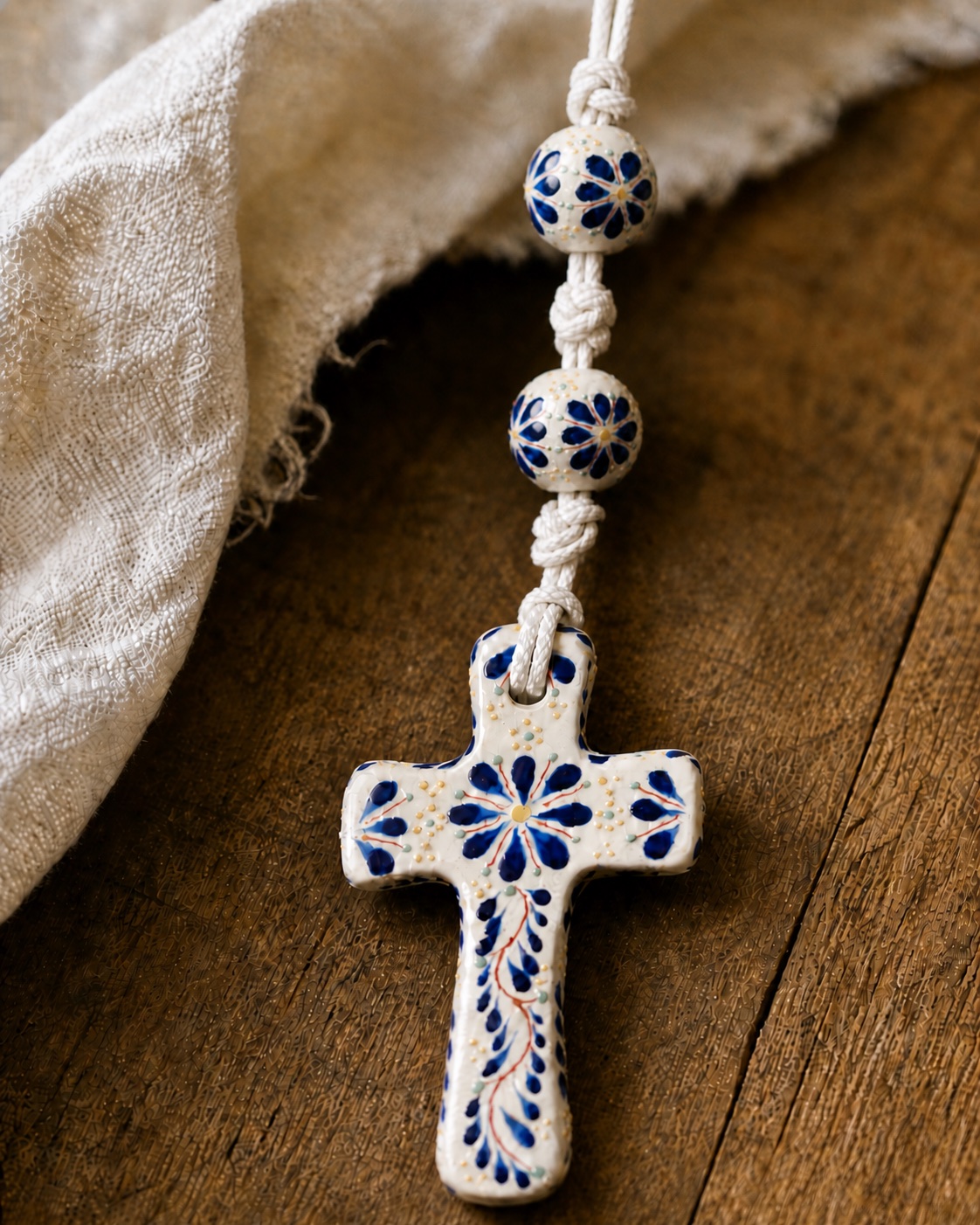 Cross detail on a handmade Talavera-style wedding lasso with blue-and-white beads