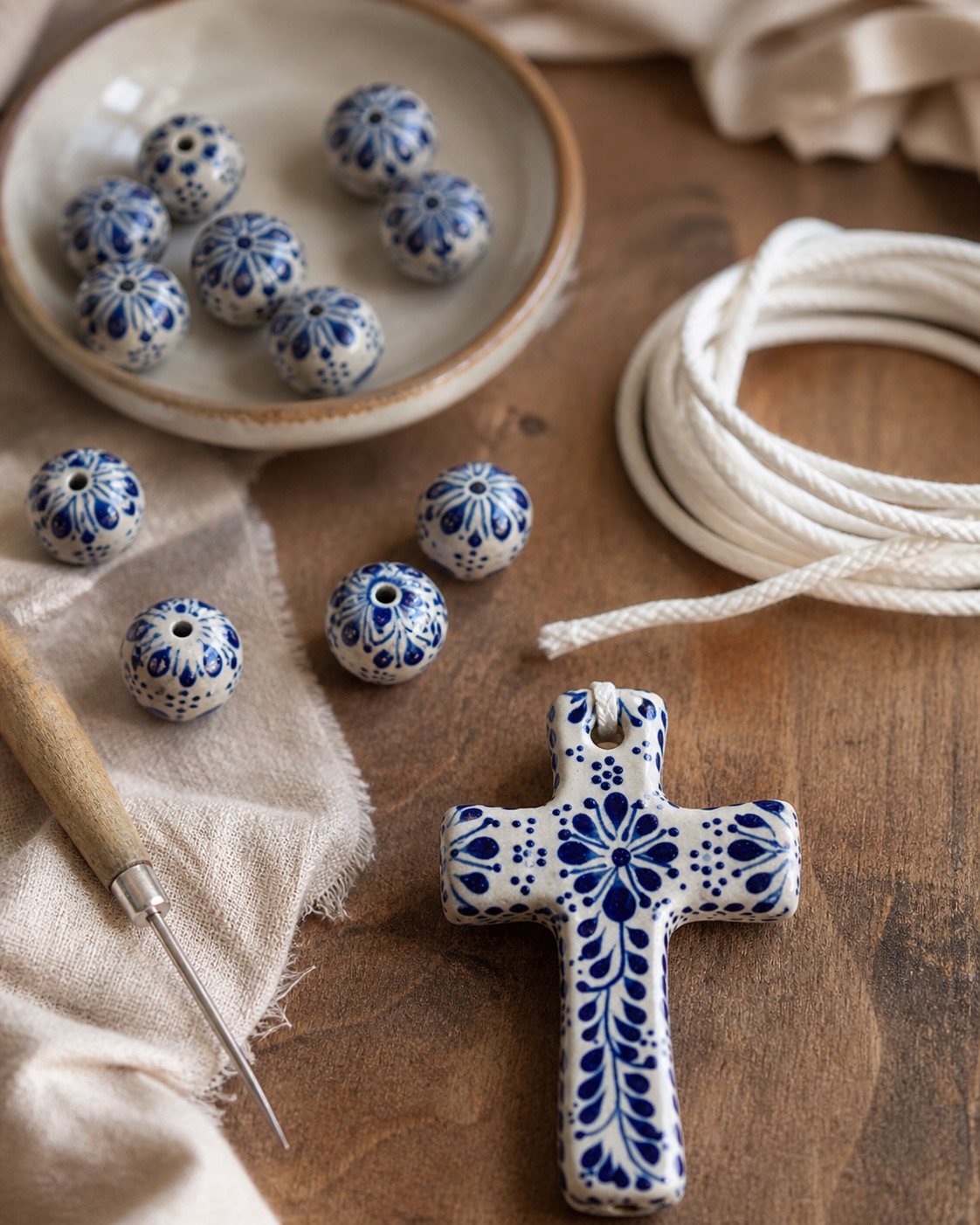 Close-up of Talavera-style blue-and-white beads and ivory cord for a handmade wedding lasso